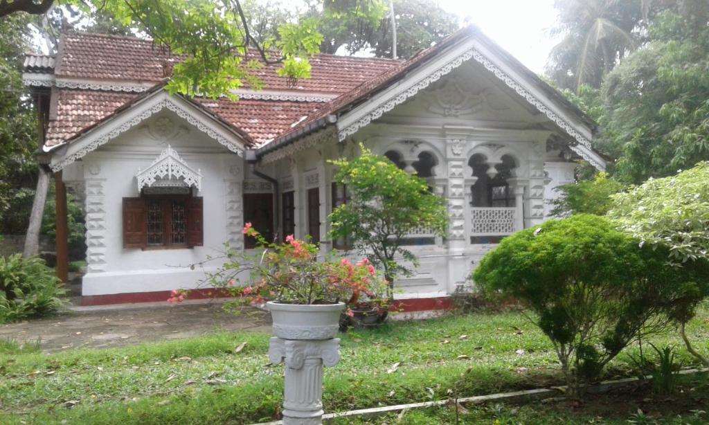 a white house with a flower pot in front of it at Kurunduwatta Villa in Hikkaduwa