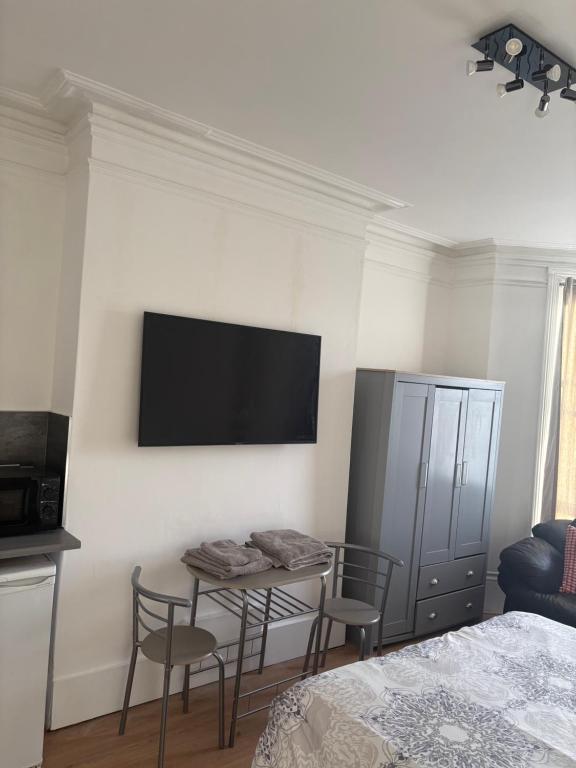a bedroom with a table and a tv on the wall at Crystal in Crystal Palace