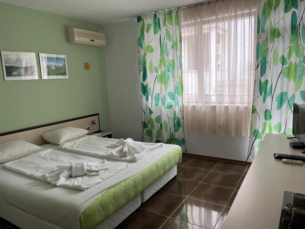 a bedroom with a bed and a window at kaLe in Ravda