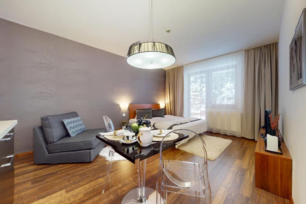 a living room with a couch and a dining room at Apartmán Deluxe Jasná in Belá
