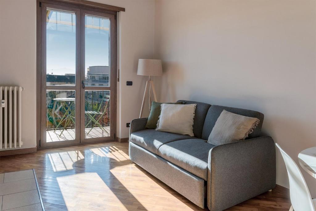 a living room with a couch and a window at Casa Fiore by Vayadù in Savigliano