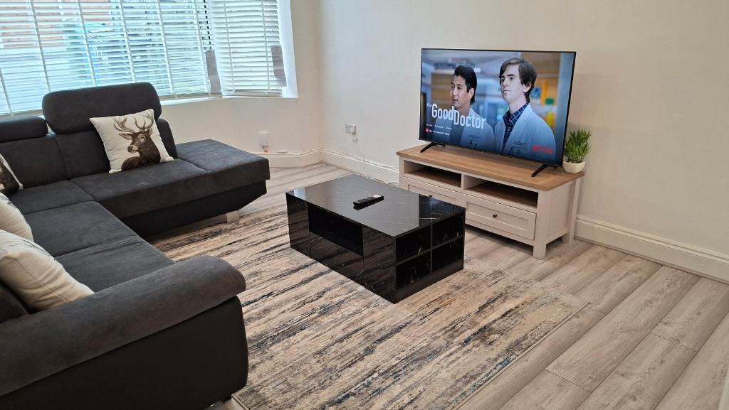 a living room with a couch and a flat screen tv at The White House in Moston