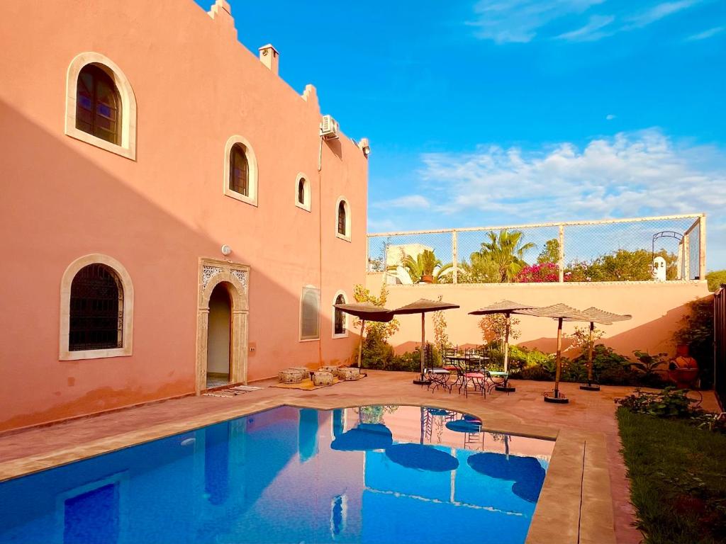 a house with a swimming pool next to a building at Palais Aya in Oulad Akkou