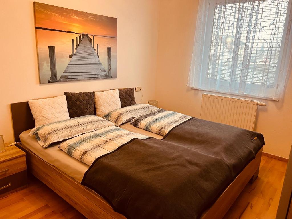 a bed in a bedroom with a picture on the wall at Appartement Gombotz in Halbenrain