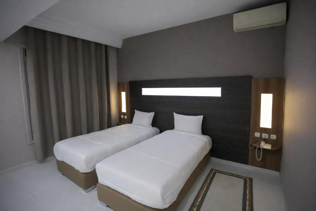 two beds in a hotel room with two beds sidx sidx at Hotel karim Tunis in Tunis