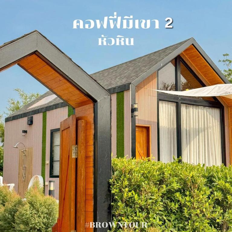 a house with a wooden door in front of it at Nordic pool villa huahin6 in HHQ