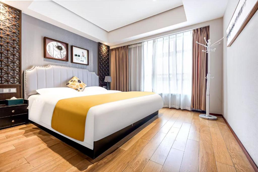 a bedroom with a large bed and a large window at ROLA&RICCI Hotel Chengdu East Branch in Chengdu