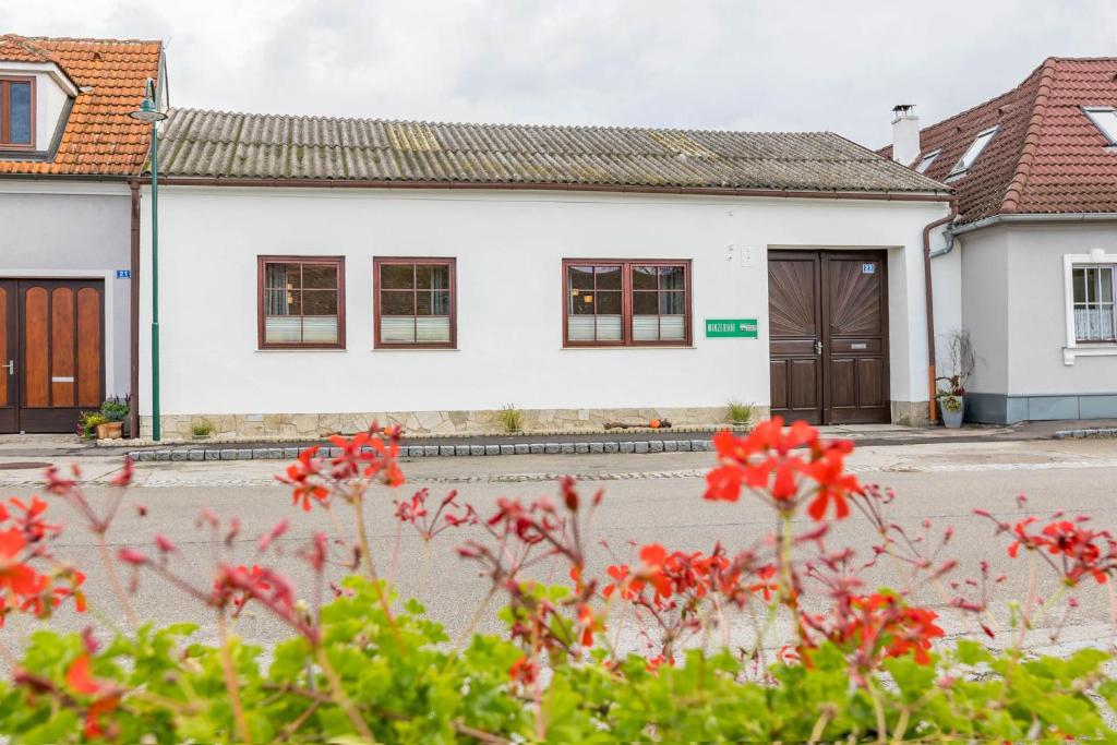 a white house with red flowers in front of it at Landhaus Krell in Mitterretzbach