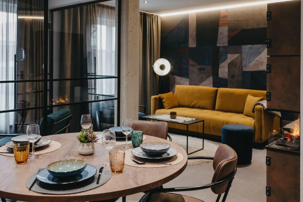a living room with a table and a yellow couch at Parzivita Suites in Wolframs-Eschenbach