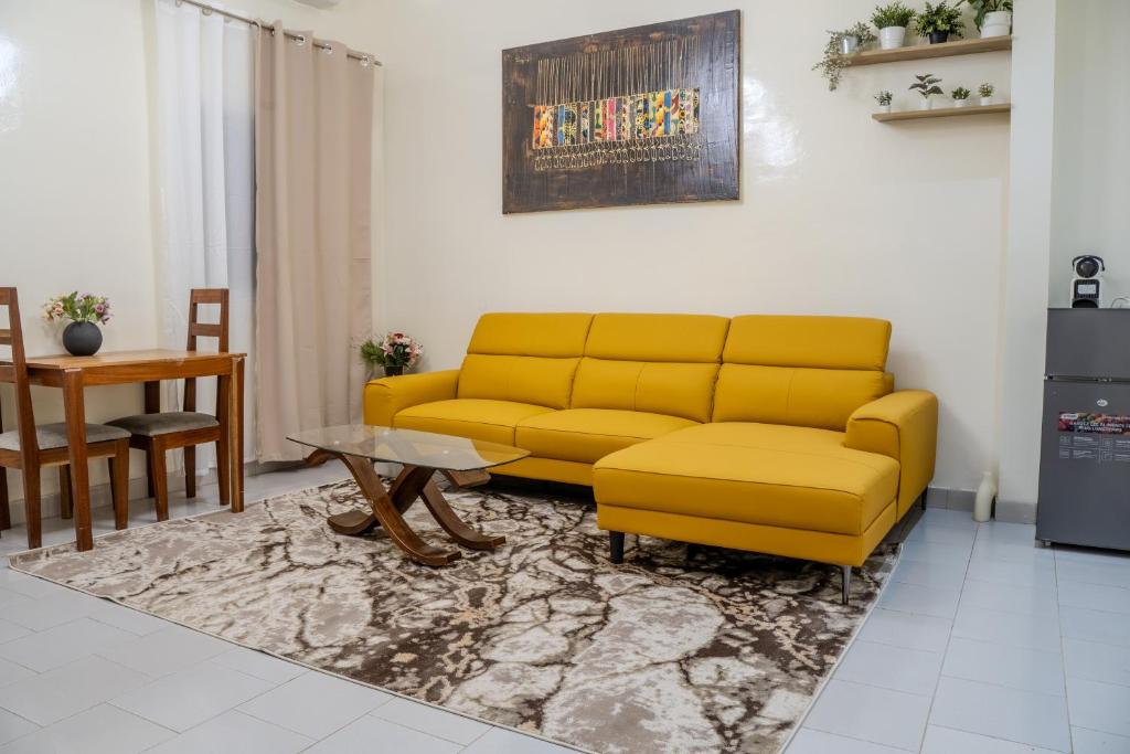 a living room with a yellow couch and a table at F2 Appart Les Ambassades Point E, Dakar in Dakar