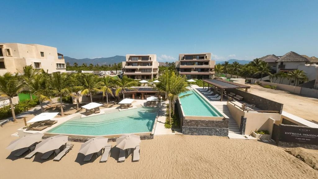 an aerial view of a resort with a swimming pool at Luxury Apartment in Playa Blanca Zihuatanejo CAUMA in Zihuatanejo