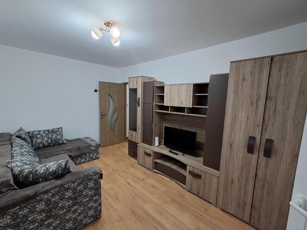 a living room with a couch and a large entertainment center at "NIB's apartment" in Caransebeş