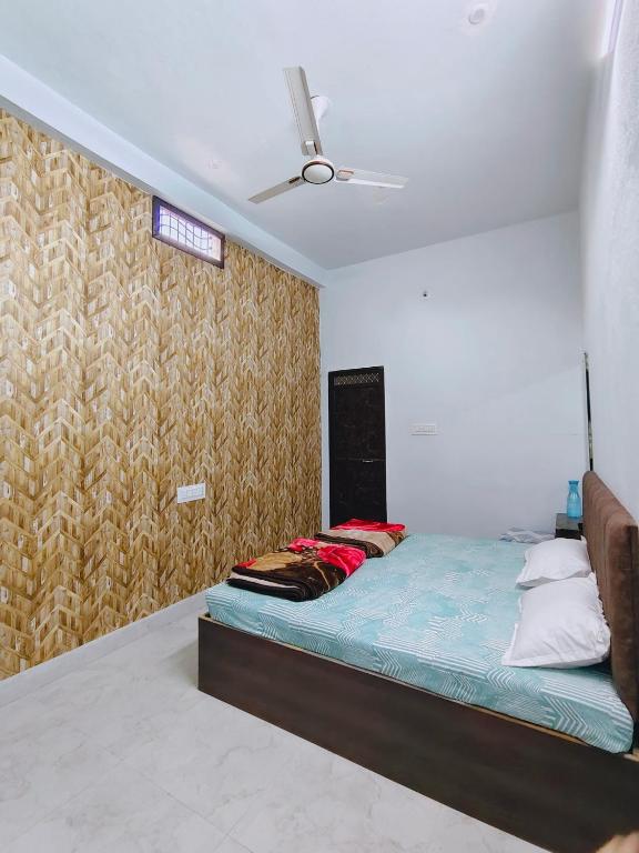 a bedroom with a bed and a ceiling fan at Shiv Lehri Homestay in Ujjain
