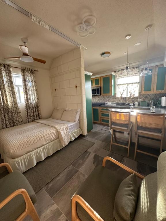 a small bedroom with a bed and a kitchen at Windy Nook - The Contemporary Tiny Home in Saint Philip