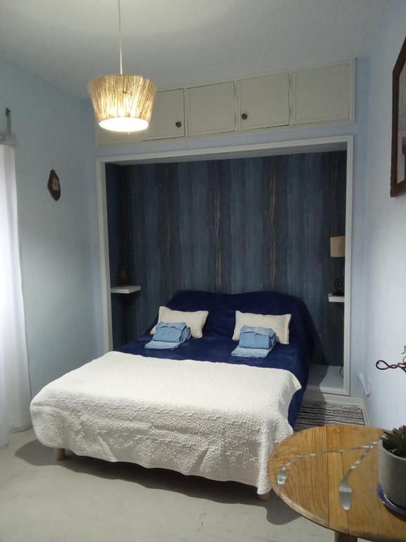 a bedroom with a bed with blue sheets and a table at casa thocamalu's in Covelo