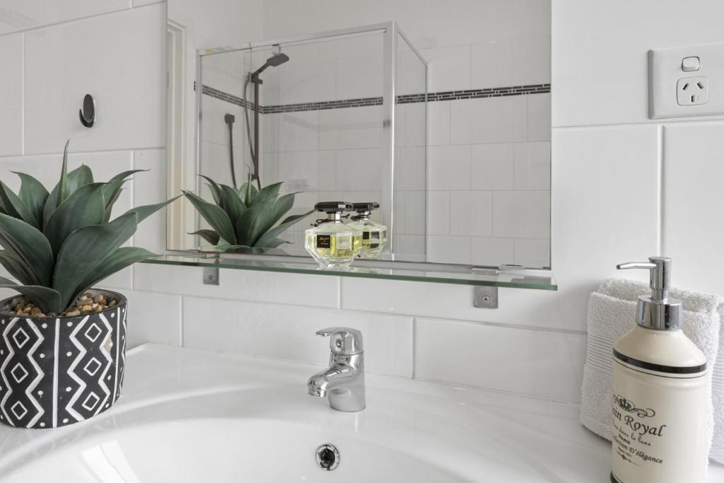 a bathroom sink with a glass shelf above it at Sunset Seas in West Beach in West Beach