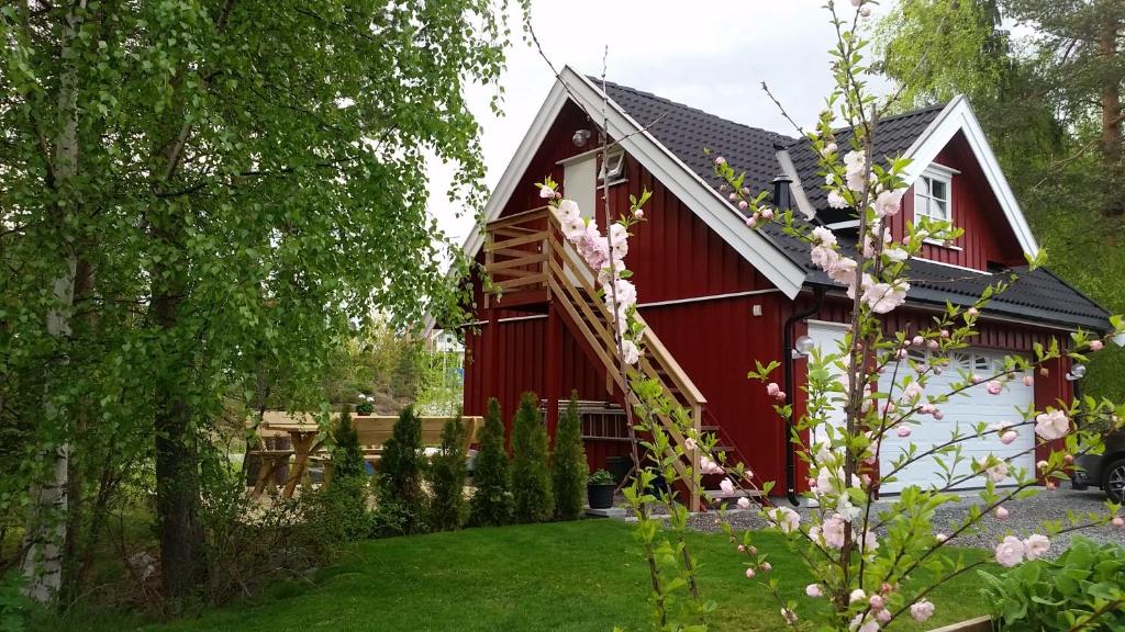 um celeiro vermelho e branco com um quintal em Ormåsen Loft em Ormåsen