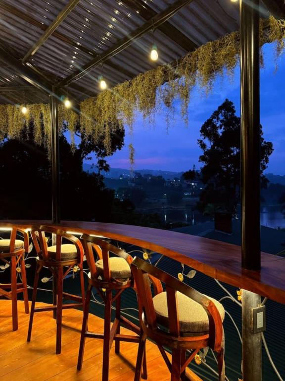 a table and chairs on a balcony with a view at Garden Gathering Room in San Lucas Tolimán