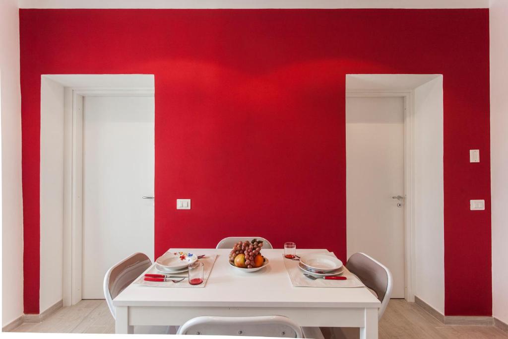 ラ・スペツィアにあるByron & Shelley Apartmentsの白いテーブルと赤い壁のダイニングルーム