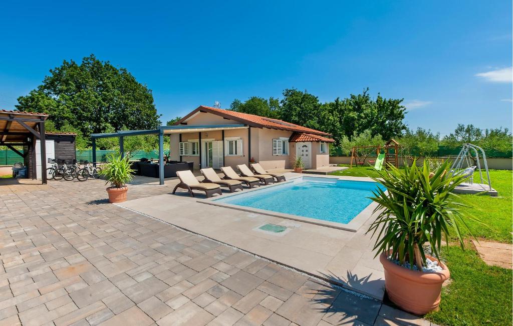 a swimming pool with lounge chairs next to a house at Gorgeous Home In Rovinj in Rovinj