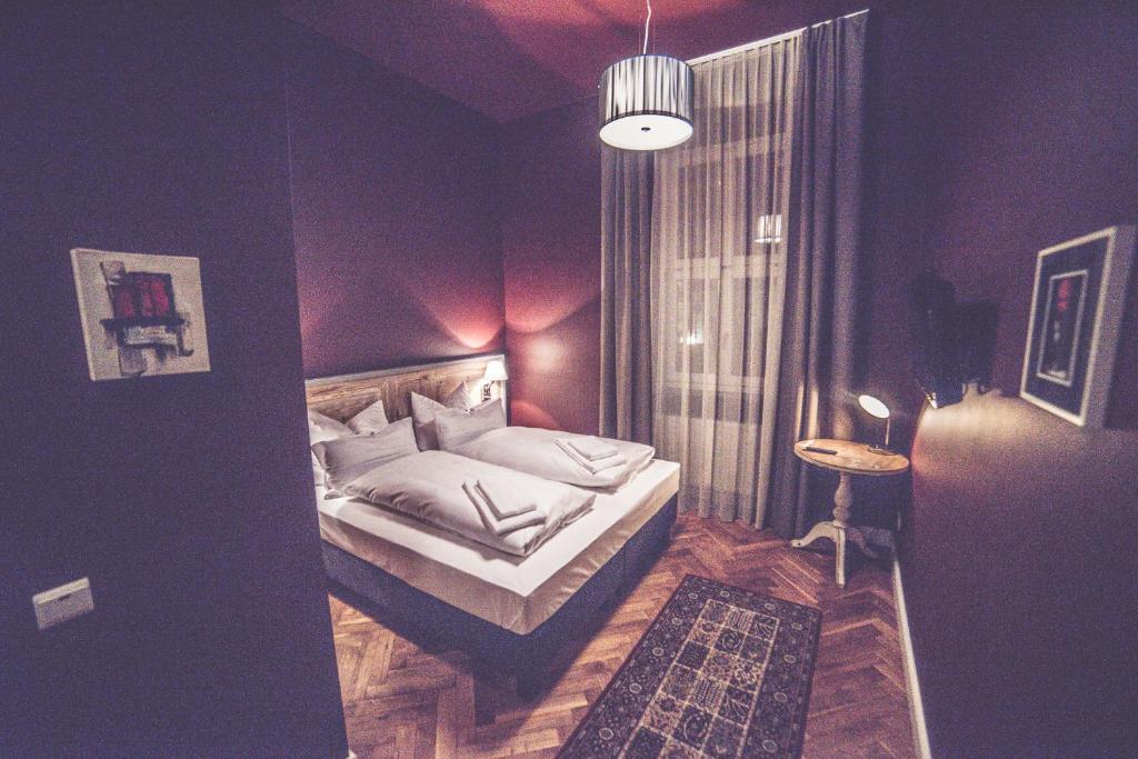 ein Schlafzimmer mit einem Bett in einem lila Zimmer in der Unterkunft Hotel Luis in Regensburg
