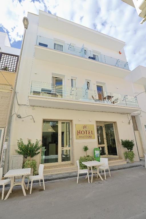 a hotel with tables and chairs in front of a building at Hotel da ettore in Porto Cesareo