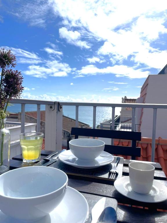 a table with plates and bowls on top of a balcony at Don Sebastiao in Sesimbra