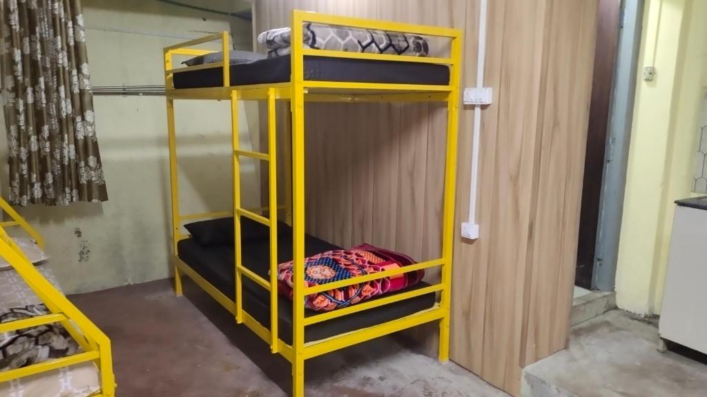a bunk bed in a room with yellow bunk beds at Hills Vacation Hostel in Darjeeling