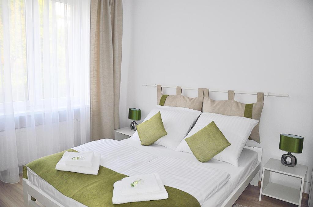 a bedroom with a white bed with two towels on it at Apartament Rosa in Jelenia Góra