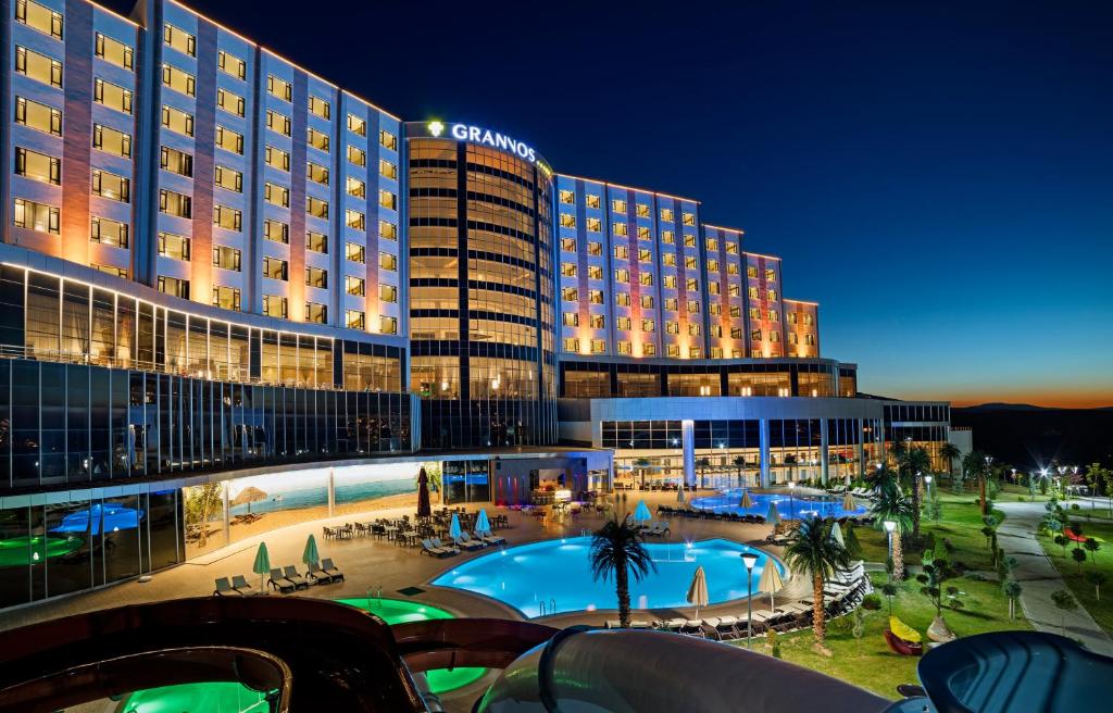 Grannos Thermal Hotel & Convention Center في هايمانا: فندق فيه مسبح امام مبنى
