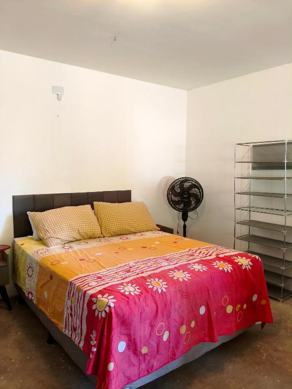 a bedroom with a bed with a pink and orange blanket at Chalé em Tatajuba in Tatajuba