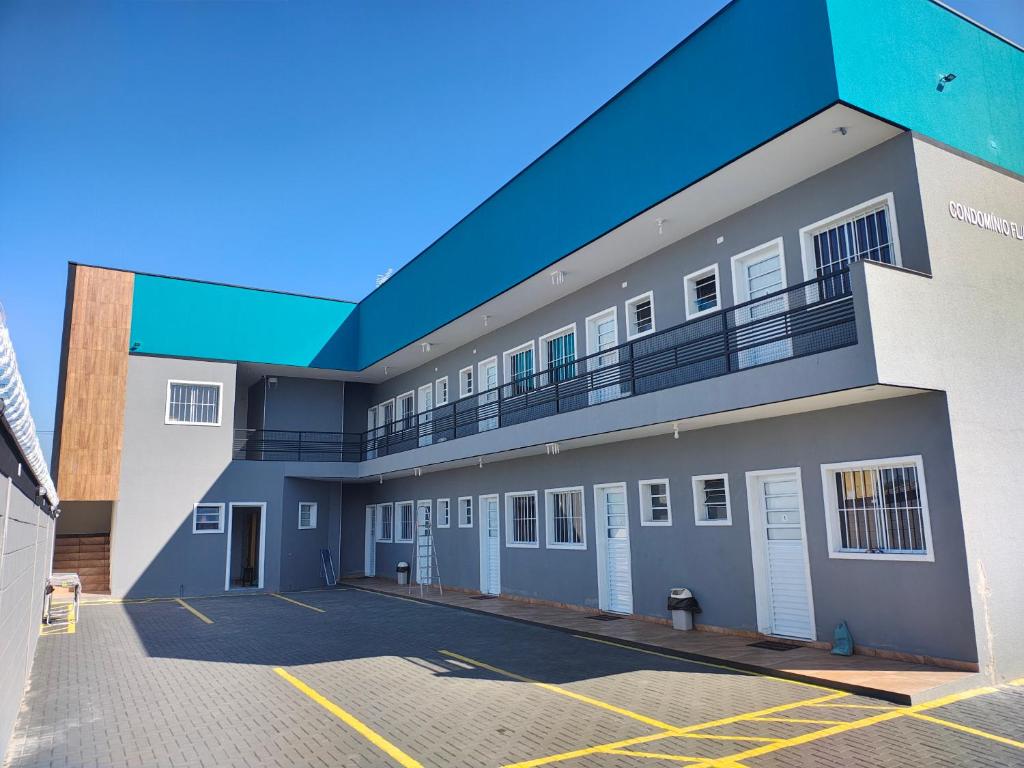 a building with a parking lot in front of it at Condomínio Flamboyant in Pindamonhangaba