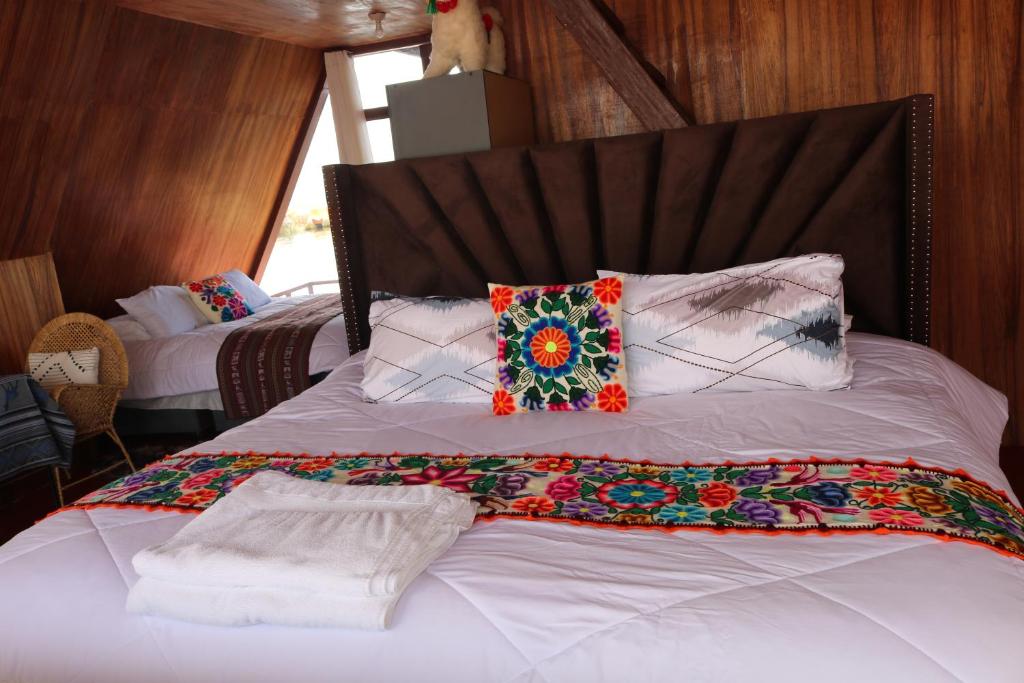 a bedroom with a bed with pillows on it at Titicaca deluxe lodge in Puno
