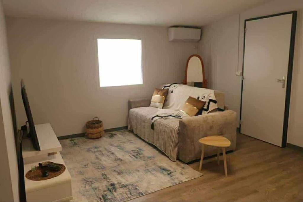 a bedroom with a bed and a table and a window at La Maison des Cocotiers in Petite Île