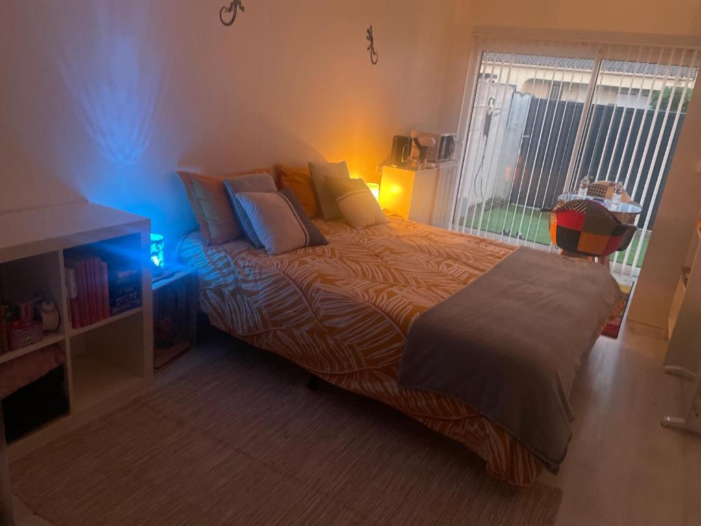 a bedroom with a bed with a blue light at Chez Fabrice in Lunel