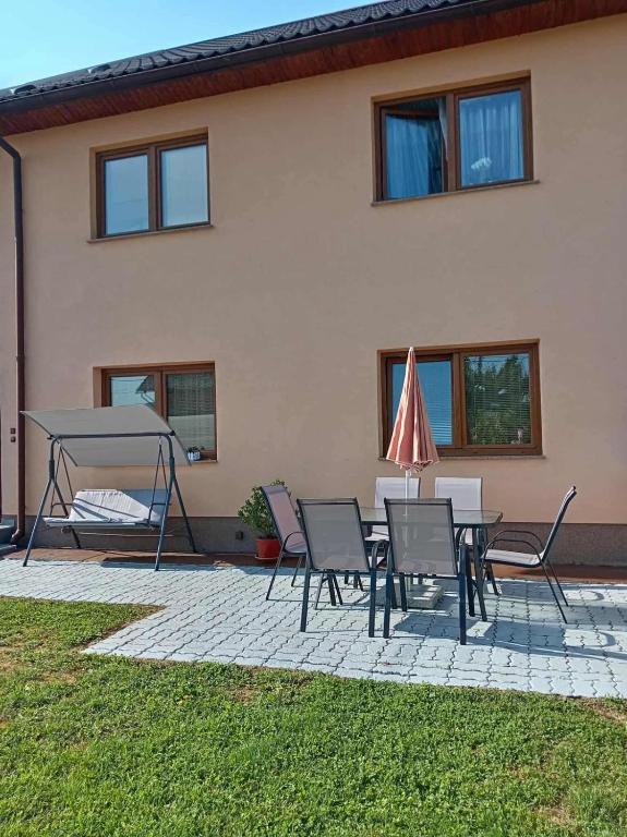 a patio with a table and chairs and an umbrella at Apartment OrMarić in Otočac