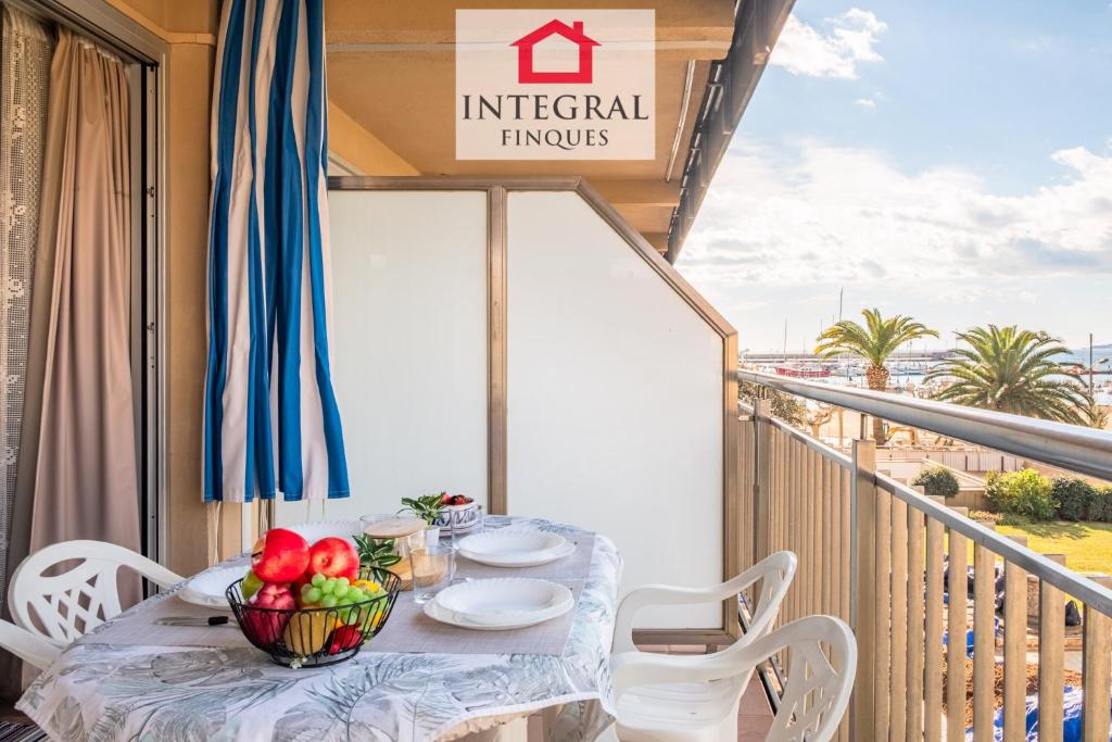 a table with a bowl of fruit on a balcony at Why Not Apartment Palamós in Palamós