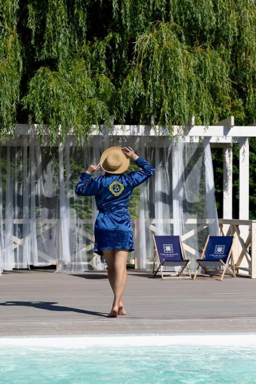 a woman in a blue dress and hat standing in the water at Casa de Buenas in Sarbinowo