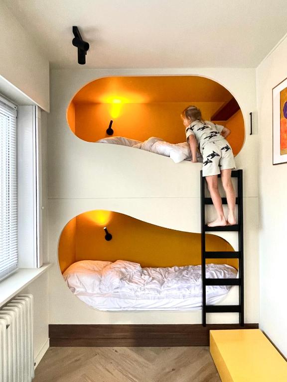 a child on a bunk bed in a room at Staf Vakantiewoning 8 ps De Haan centrum in De Haan