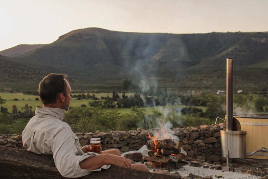 a man sitting in front of a fire pit at Valley View Escape in Uitkeer