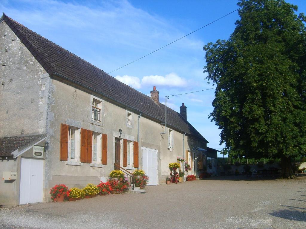 a white building with orange shuttered windows and a tree at Armalou in Pouilly-sur-Loire