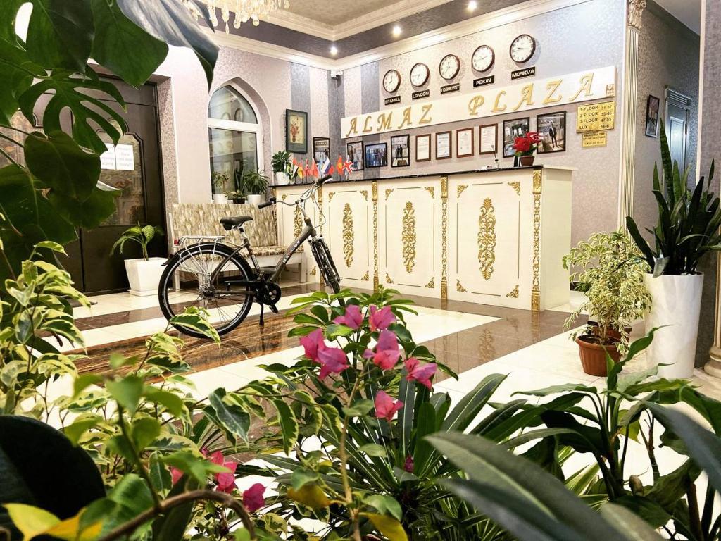 a bike parked in a room with plants at Almaz PLAZA in Tashkent