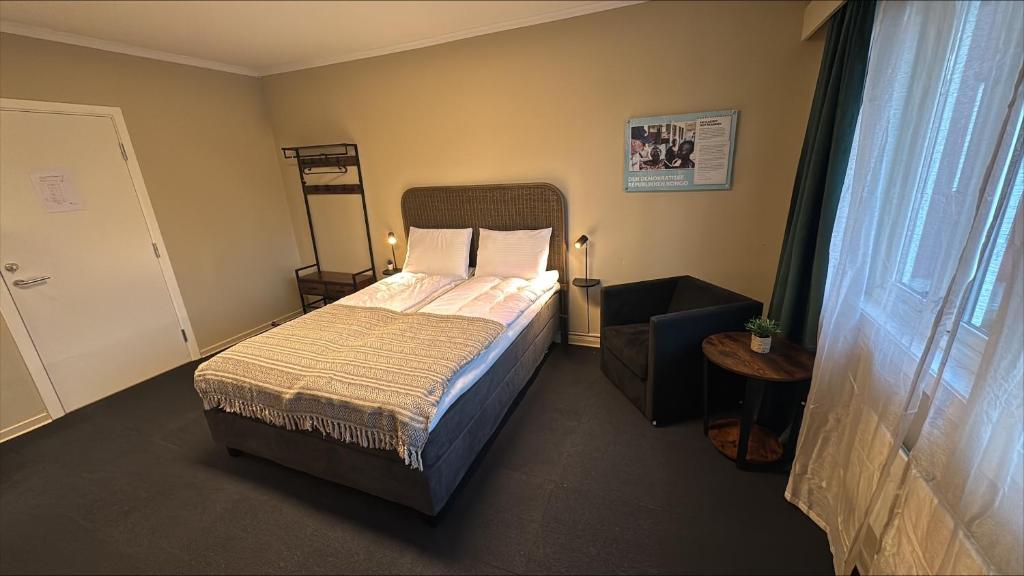 a small bedroom with a bed and a window at Stayover Lista in Farsund