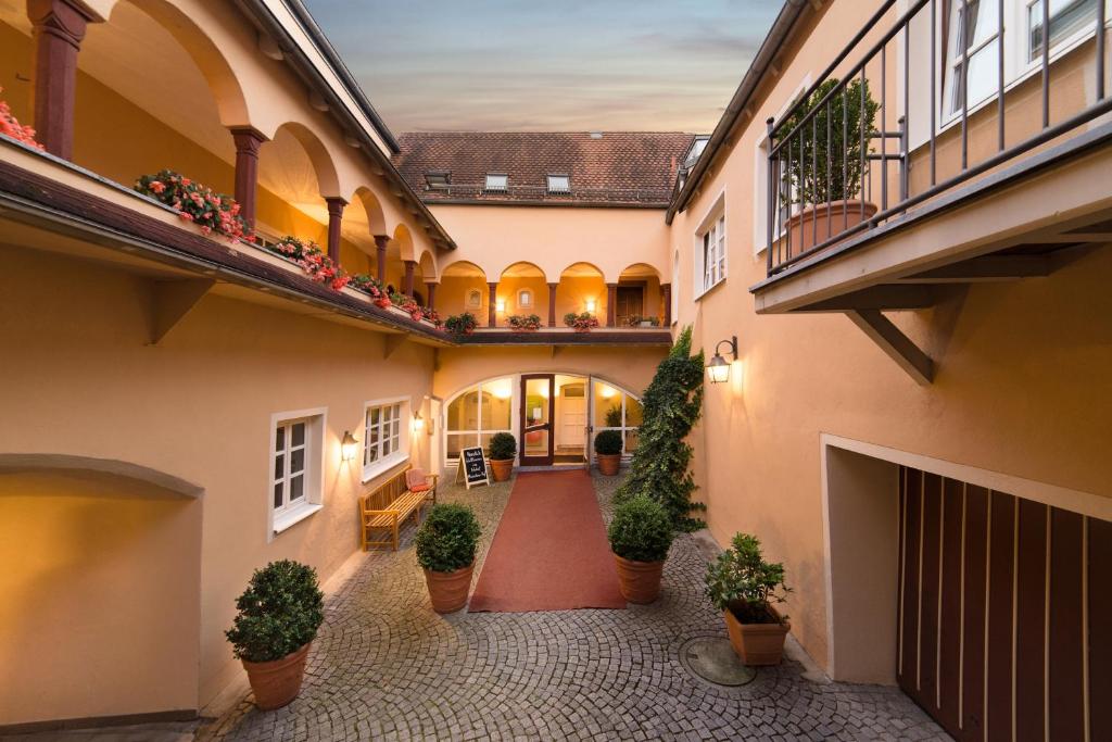 a courtyard of a building with potted plants at Boardinghouse Pfarrkirchen in Pfarrkirchen