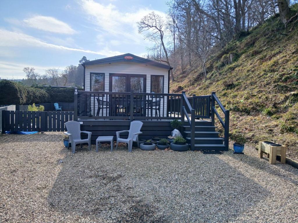 a small house with two chairs and a staircase at The Robin's Nest in Fochabers