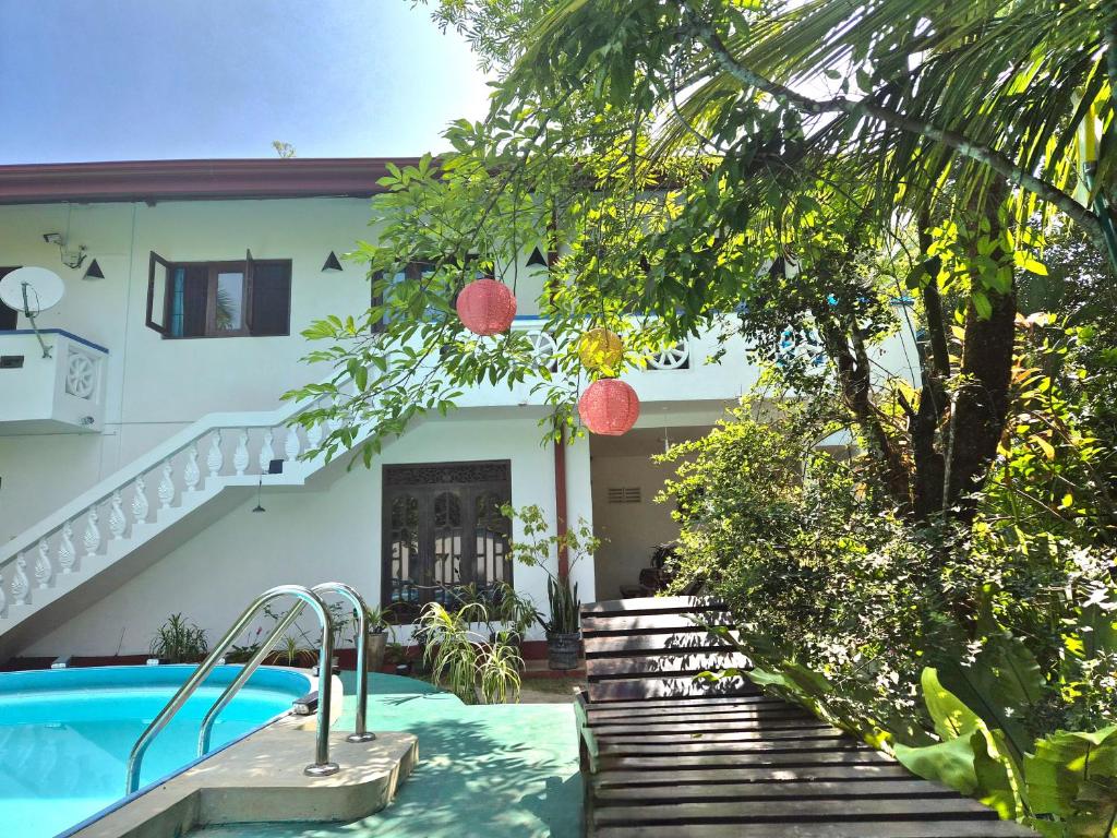 a house with a swimming pool in front of it at Nelum Vegan House in Bentota