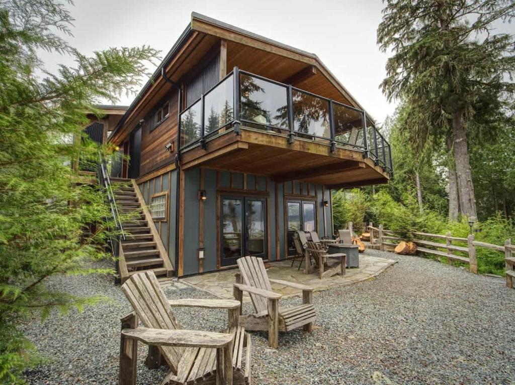 a house with a deck and some chairs at Going Coastal AB - Oceanfront - Pet Friendly in Port Renfrew