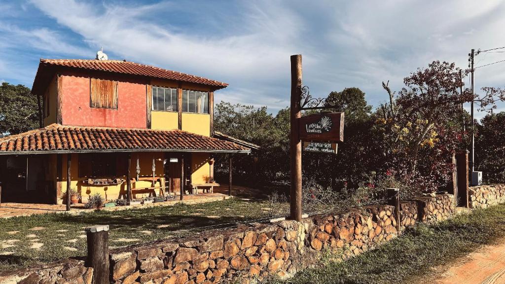 a building with a sign next to a stone wall at Amazing house with chalet and a beautiful garden in Sêrro