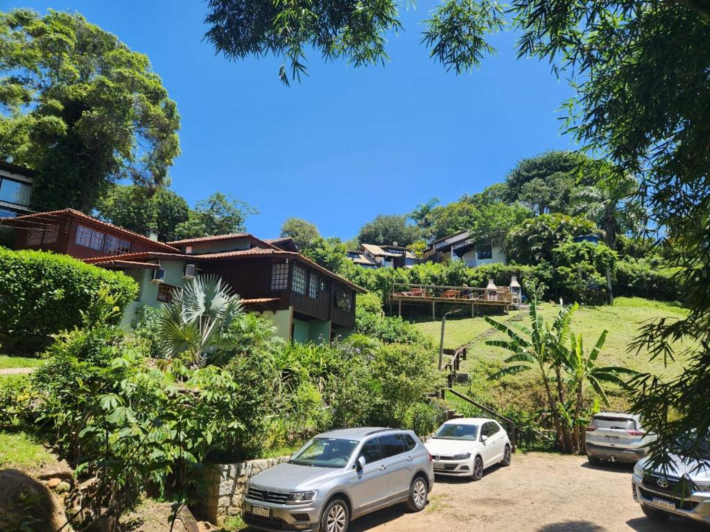 two cars parked in front of a house at Morada Sunset Vista Para o Mar in Praia do Rosa