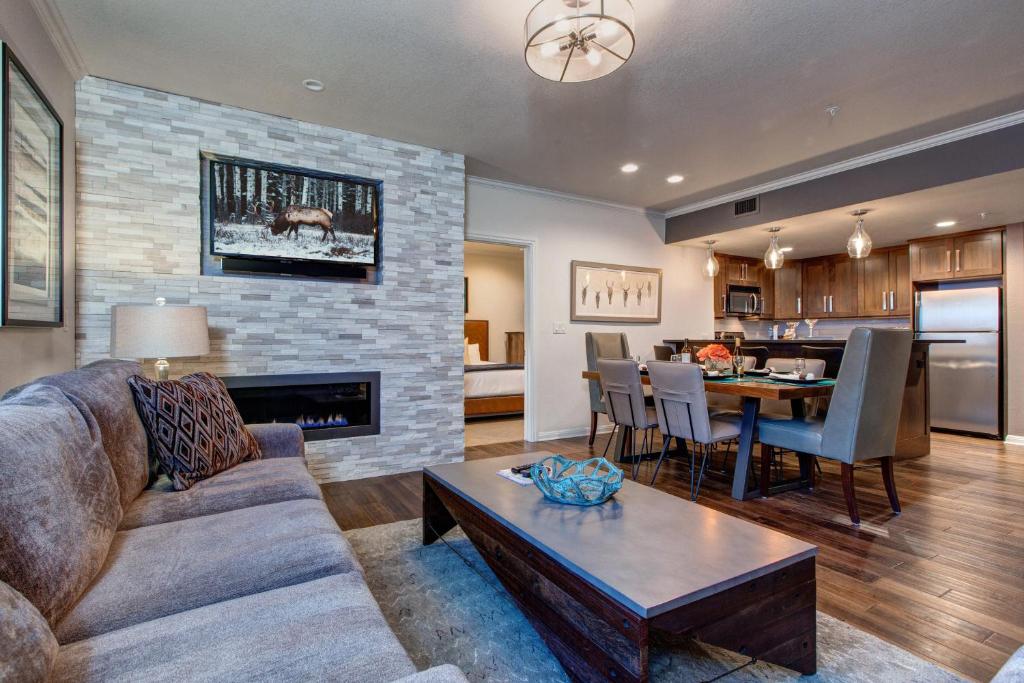 a living room with a couch a table and a fireplace at Abode on Lower Main Street in Park City